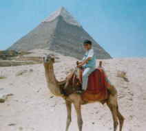 ＜写真＞ピラミッドの遙か手前で、ラクダと一緒にカメラ目線のおひねる＜写真＞