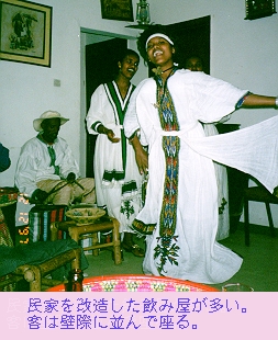 （写真）民家を改造した飲み屋で、白いバスローブ状の民族衣装を着た男女が歌って踊る（写真）