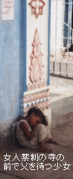 （写真）女人禁制の寺の門の前で、中に入った父親を待つ少女が座りながら居眠りをしている（写真）