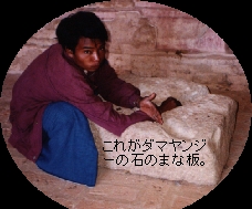 （写真）ガイドを買ってでた男が、石のまな板の上に自分の腕を乗せて、切る真似をしている（写真）
